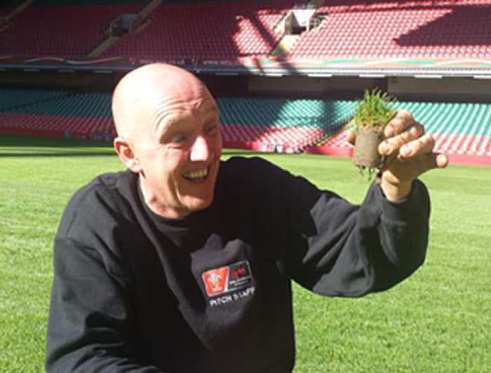 Groundskeeper for the Milennium stadium happily holding a sample of turf showing improved root structure